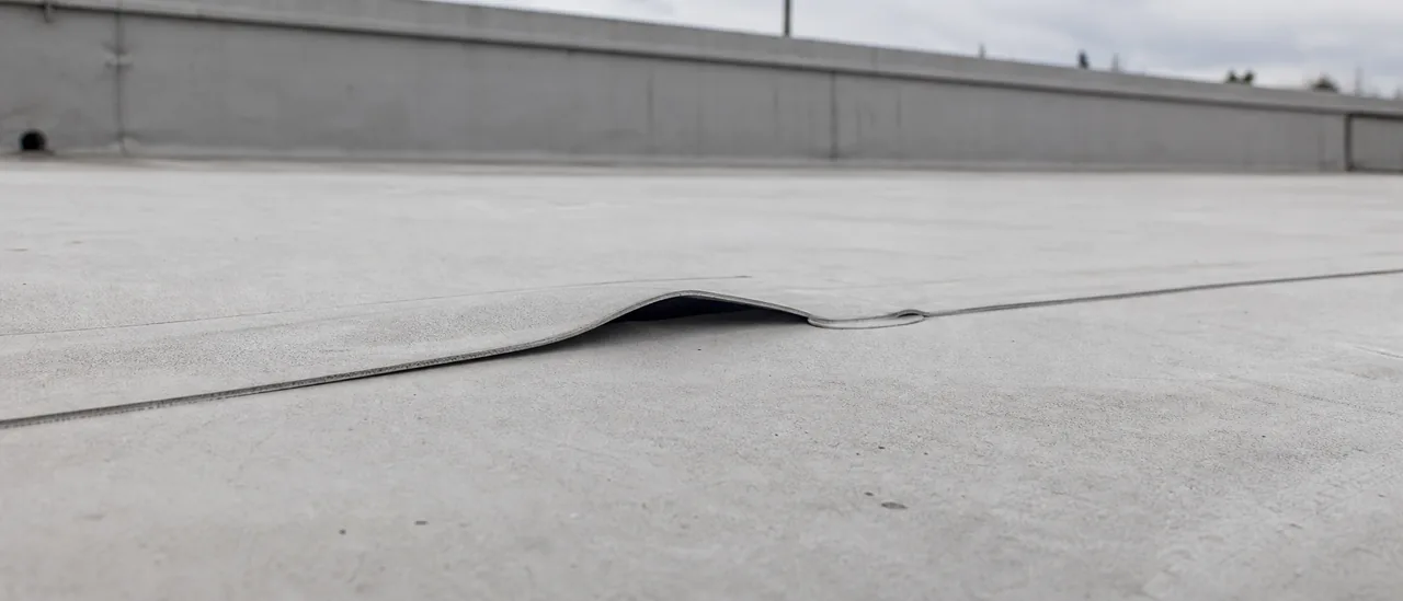Educational illustration explaining what causes separated flat-roof seams.