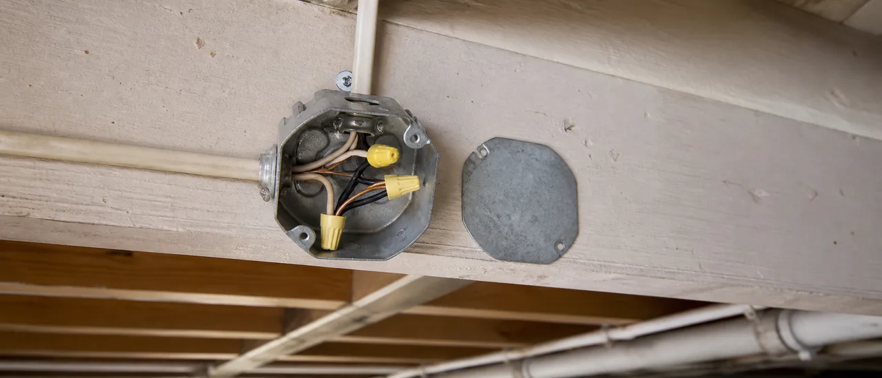 Educational illustration explaining what do open junction boxes or missing covers mean on a home inspection.