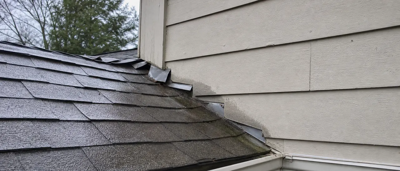 Educational illustration explaining what causes a roof leak where the roof meets a wall.